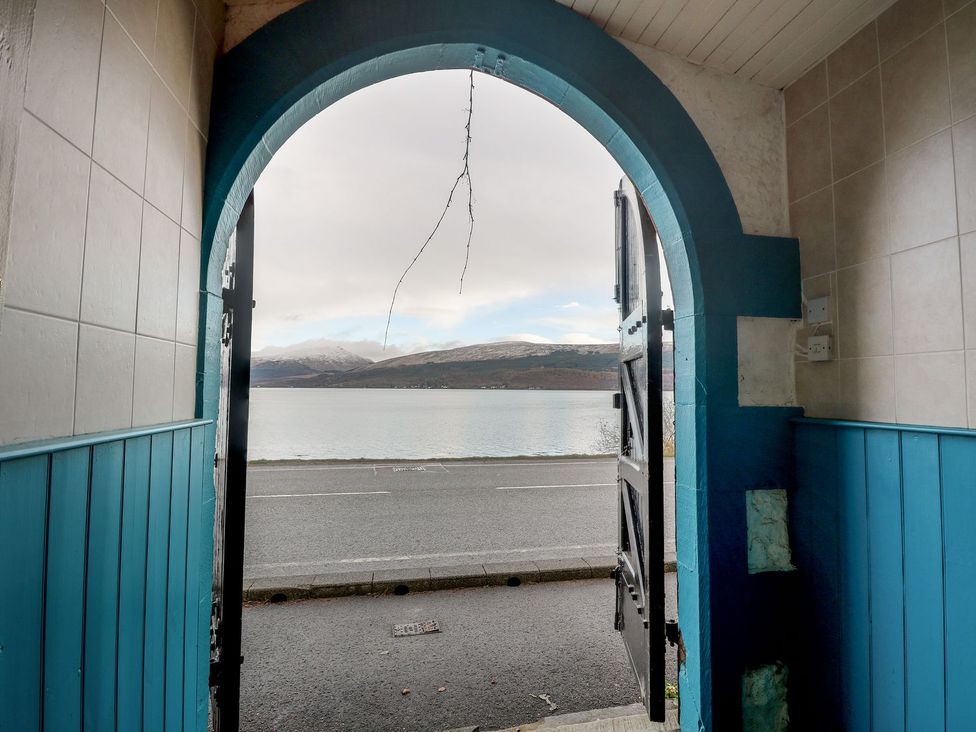 An entrance view with a door leading to water and mountains at Newton Hall in Inveraray