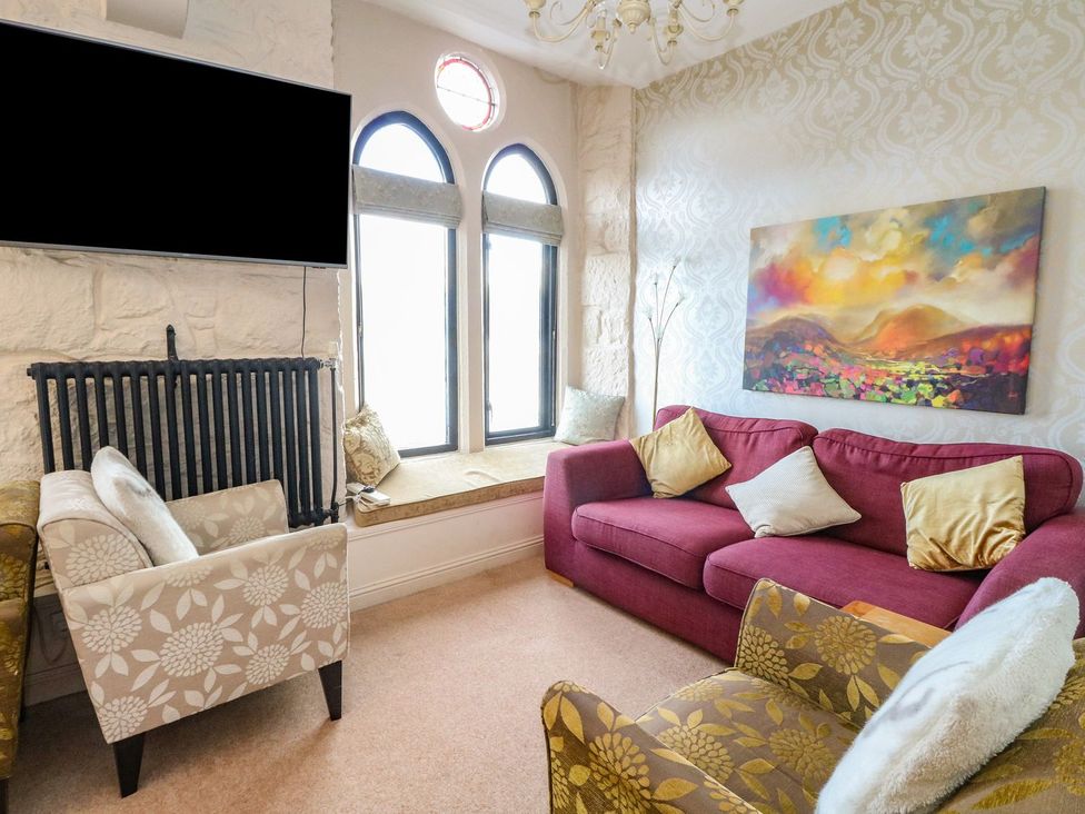 A living room with a sofa and armchair at Newton Hall in Inveraray