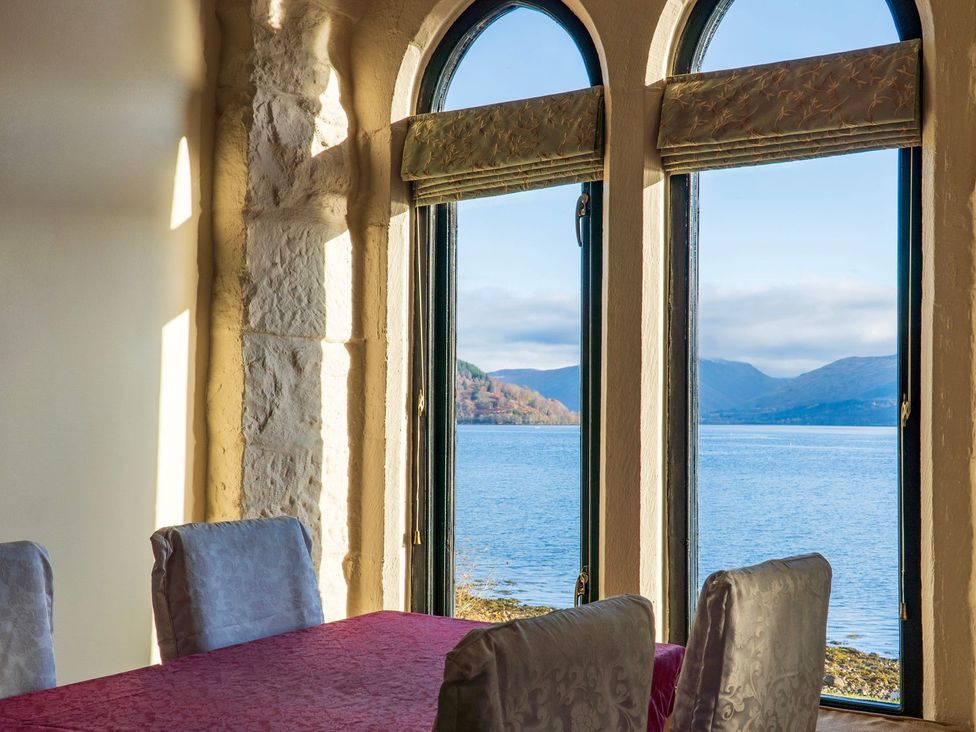 A dining room with a view of the water at Newton Hall in Inveraray
