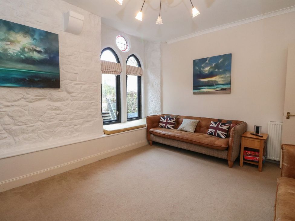 A living room with a sofa and paintings at Newton Hall in Inveraray