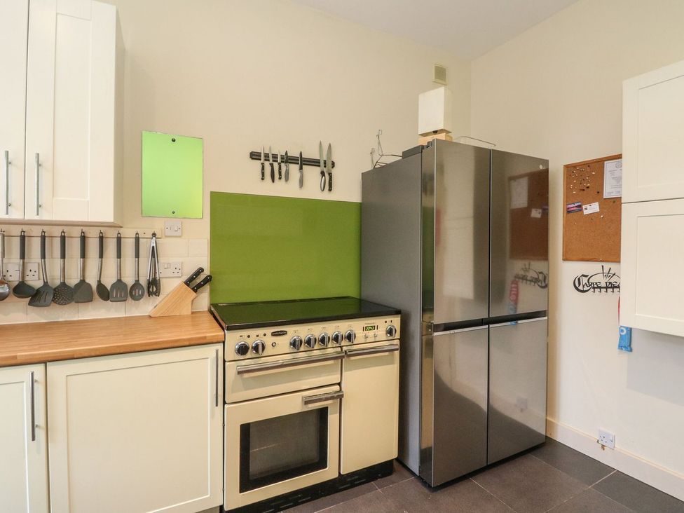 A kitchen with a stove and refrigerator at Newton Hall Inveraray