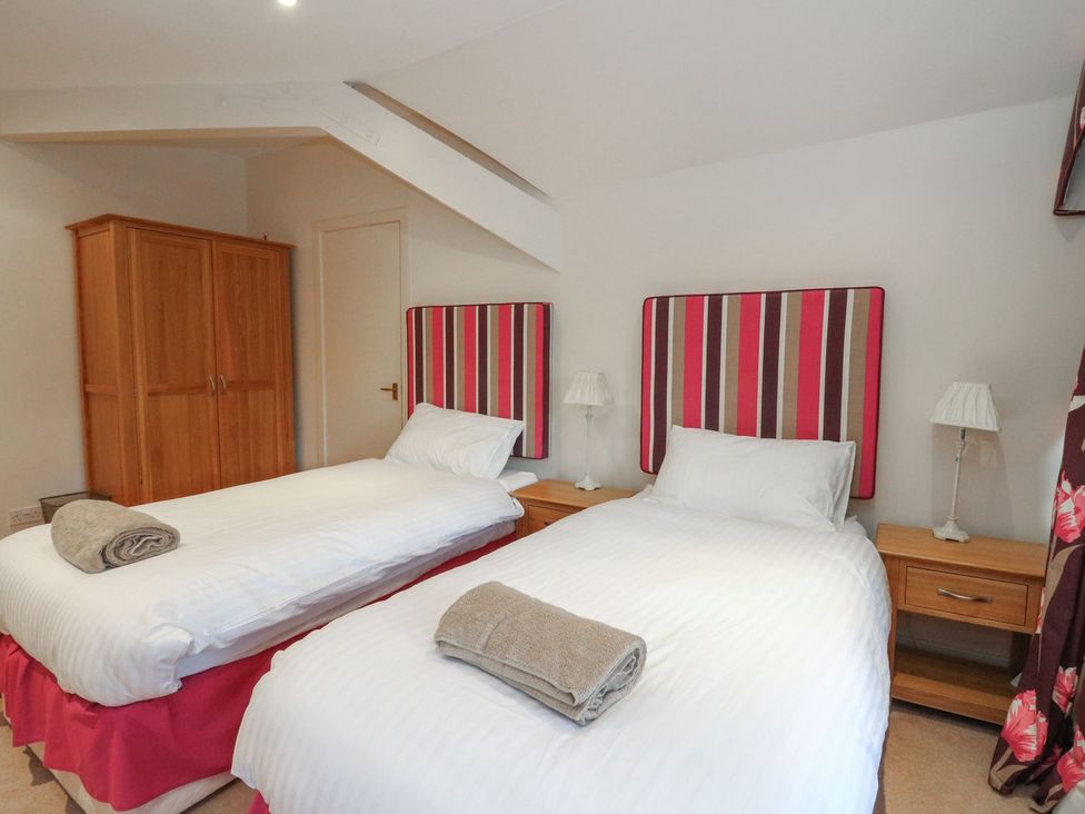 A bedroom with two single beds and a wardrobe at Newton Hall in Inveraray