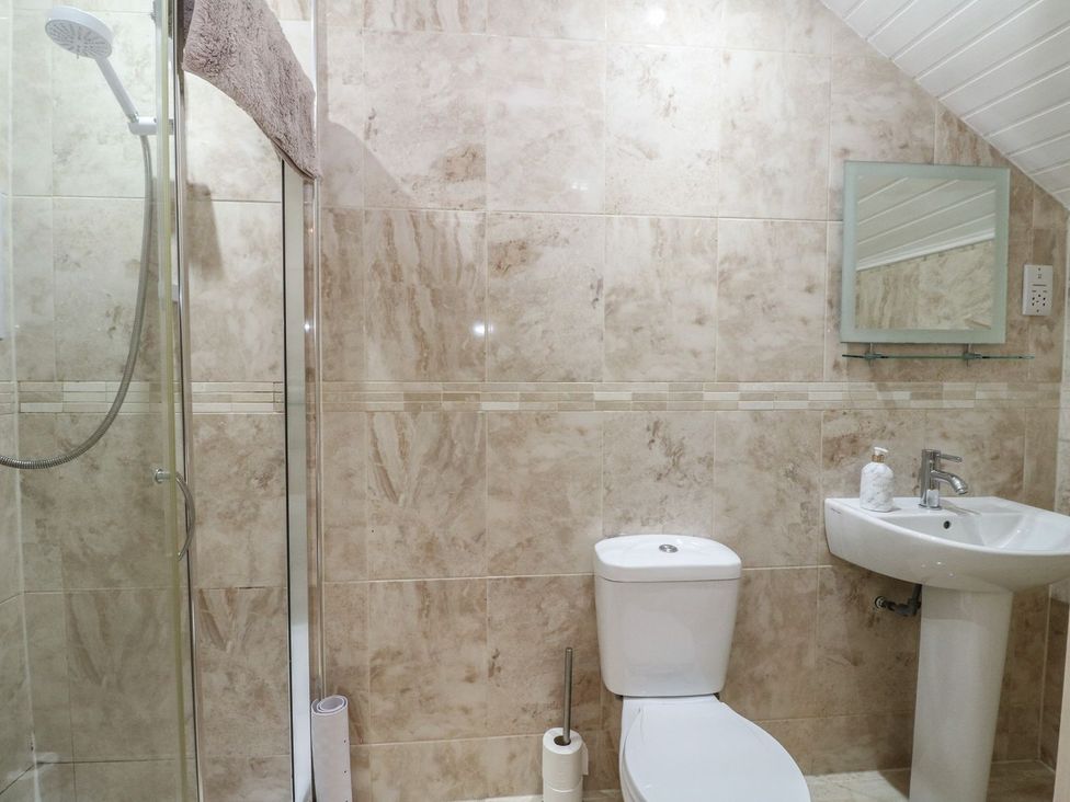 A bathroom with a shower, toilet, and sink at Newton Hall in Inveraray