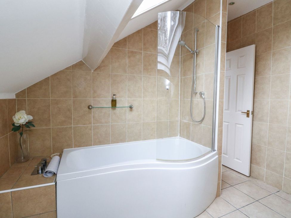 A bathroom with a bathtub and shower at Newton Hall in Inveraray