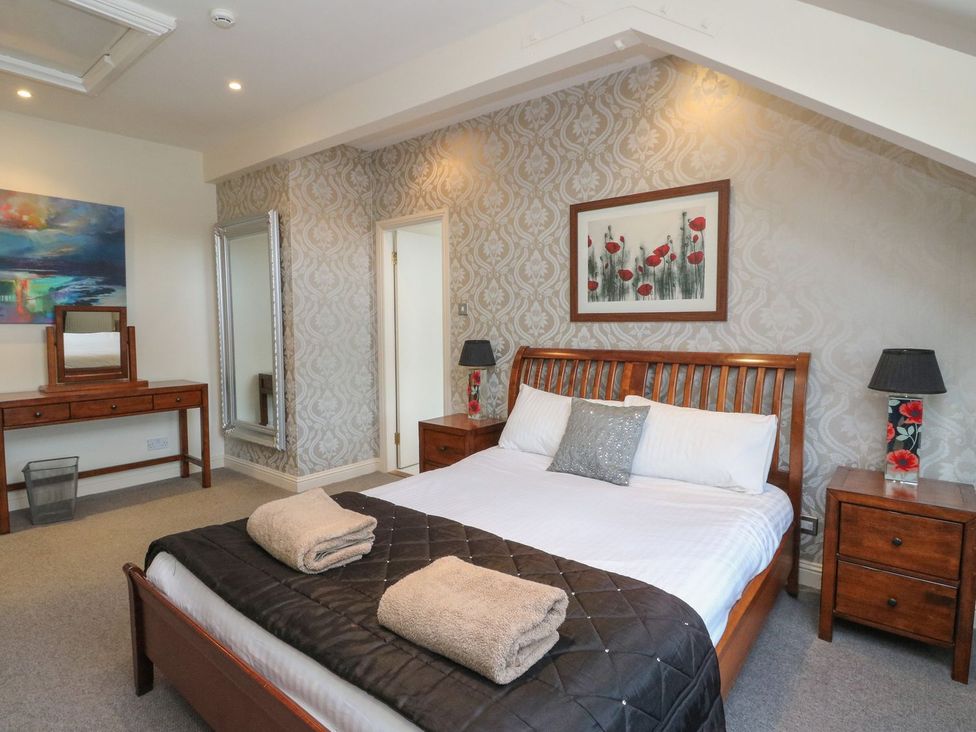 A bedroom with a bed and dresser at Newton Hall in Inveraray