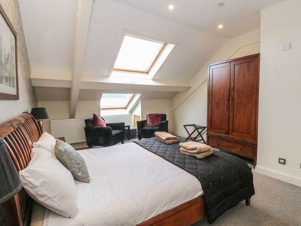 A bedroom with a bed and chairs at Newton Hall in Inveraray