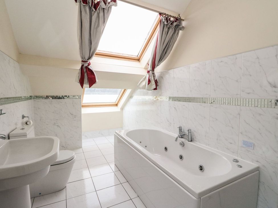 A bathroom with a bathtub and a toilet at Newton Hall in Inveraray