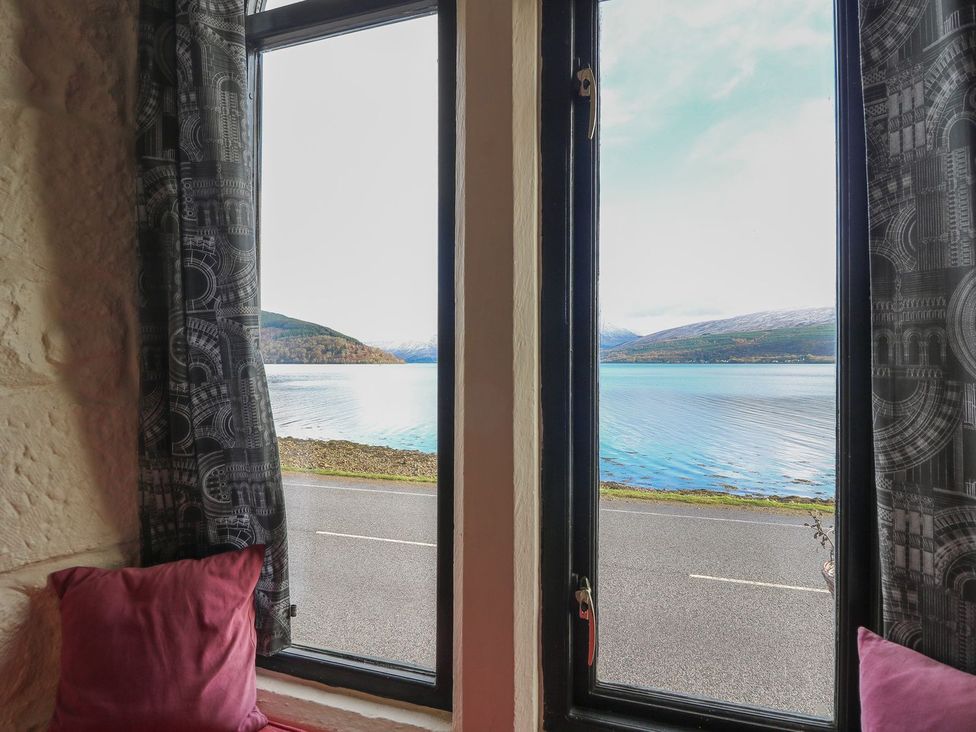 A window view overlooking water and mountains at Newton Hall Inveraray