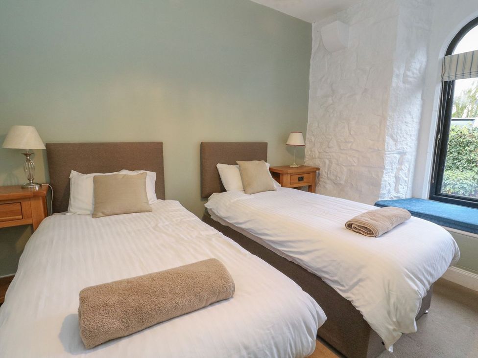 A bedroom with two beds and a nightstand at Newton Hall in Inveraray