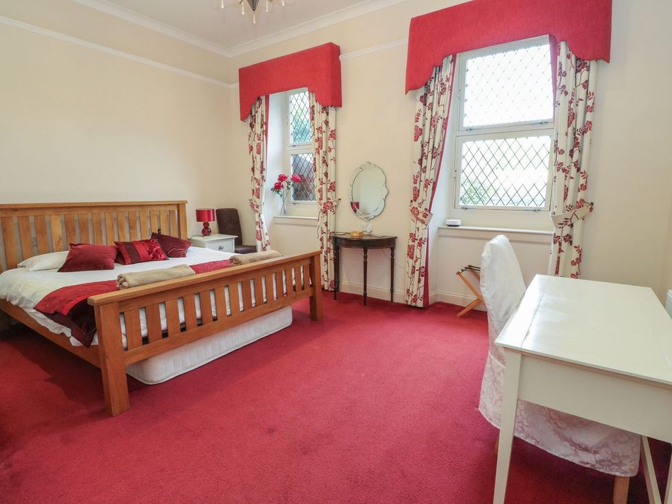 A bedroom with a bed and desk at Newton Hall in Inveraray
