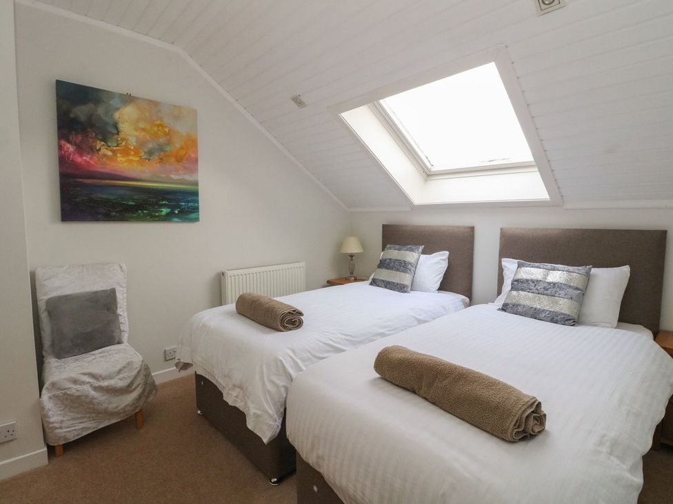 A bedroom with two beds and a painting at Newton Hall in Inveraray