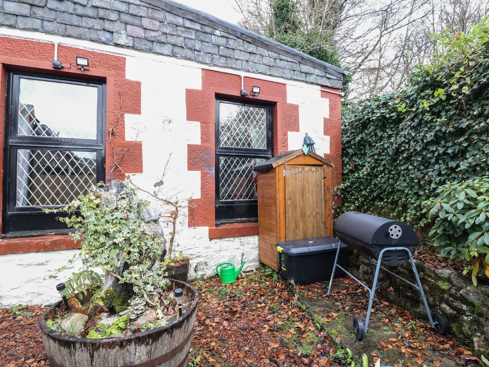 An outdoor area with a wooden shed and grill at Newton Hall in Inveraray