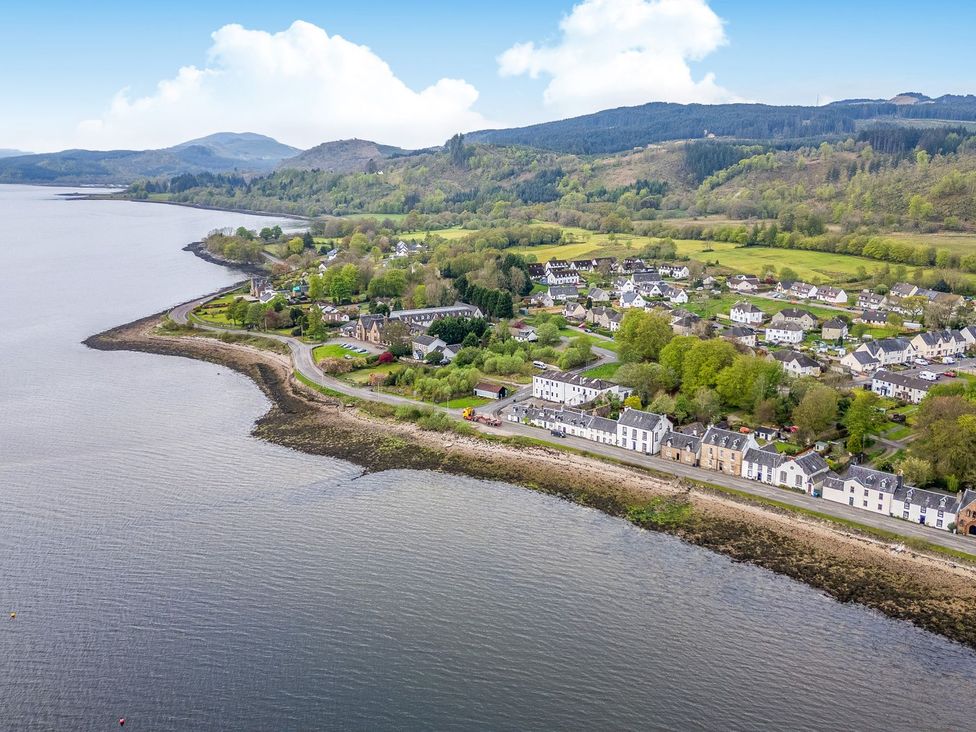 A view of a coastal area with houses and mountains at Newton Hall in Inveraray