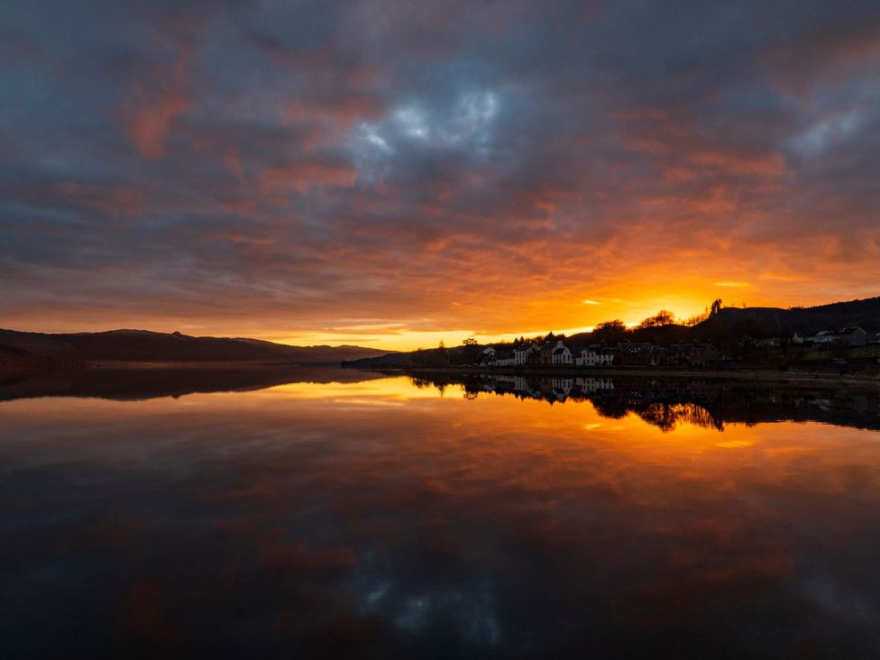 A landscape with a sunset over water at Newton Hall Inveraray