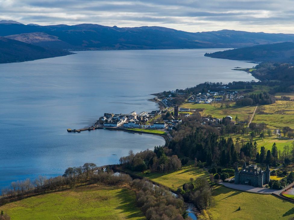 An aerial view of a river with a town along the shore at Newton Hall in Inveraray