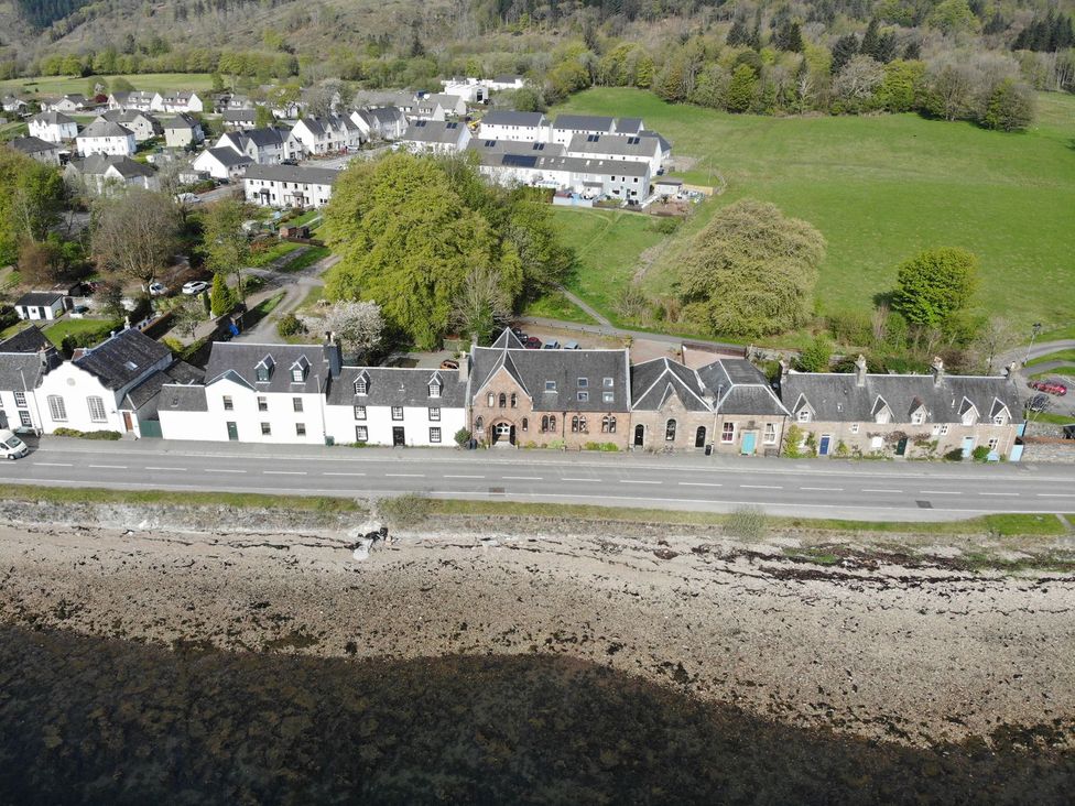 An aerial view of houses and trees near the water at Newton Hall in Inveraray