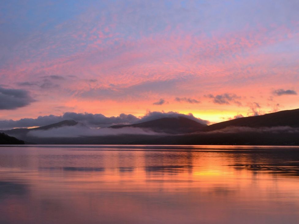 A landscape view of mountains and water during sunset at Newton Hall in Inveraray