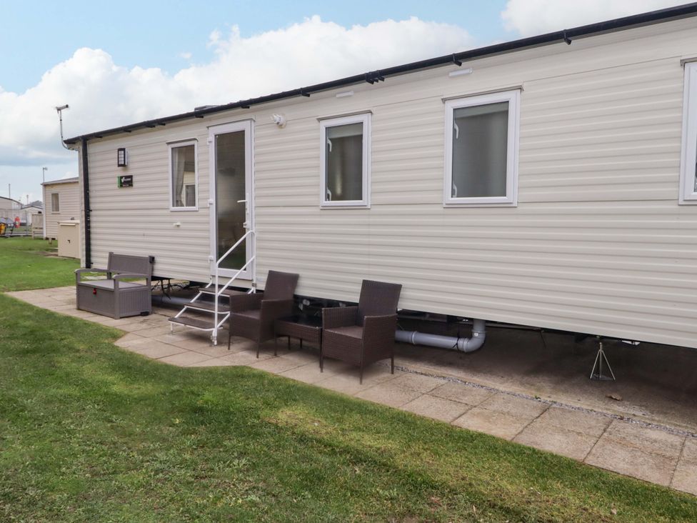 A mobile home with chairs and a table outside at 47 Chestnut Road Porthcawl