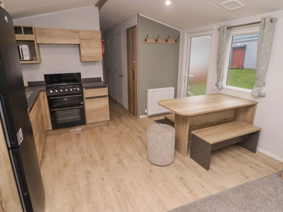 A kitchen with furniture and appliances at 47 Chestnut Road in Porthcawl