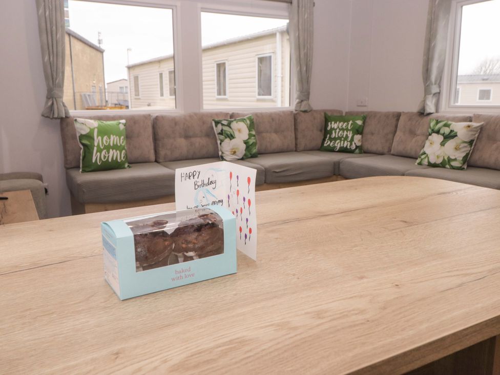 A living room with a cake and birthday card on the table at 47 Chestnut Road in Porthcawl