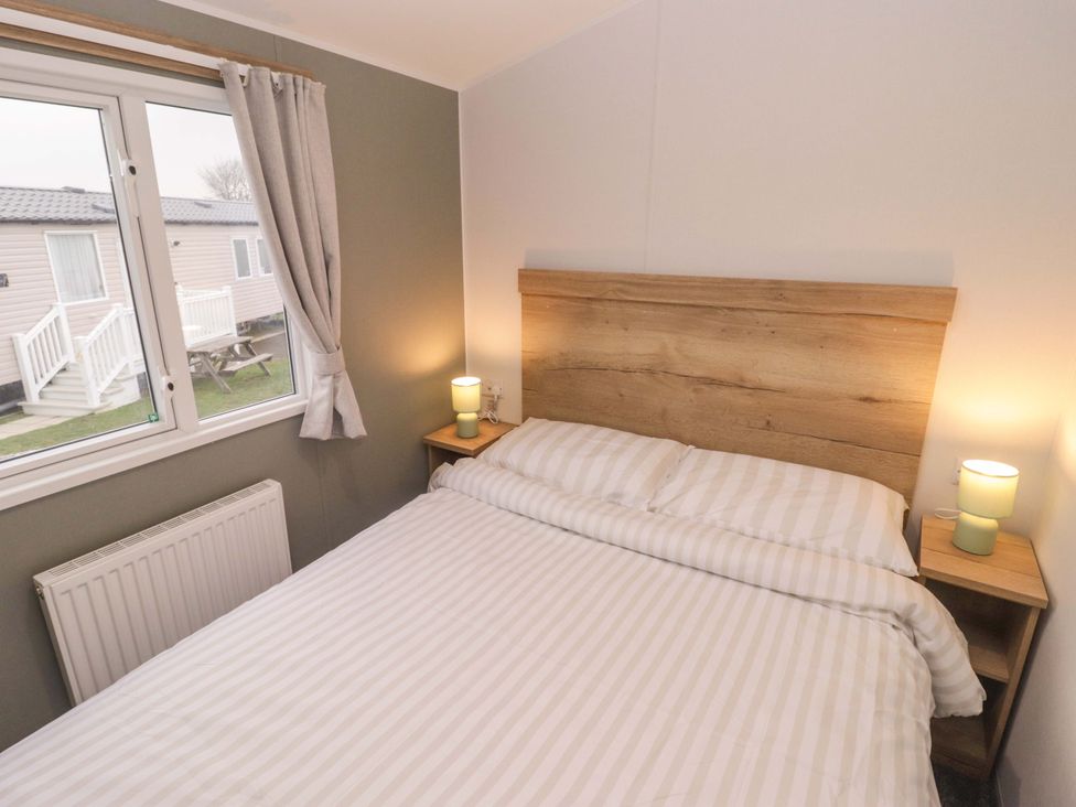 A bedroom with a bed and window at 47 Chestnut Road Porthcawl