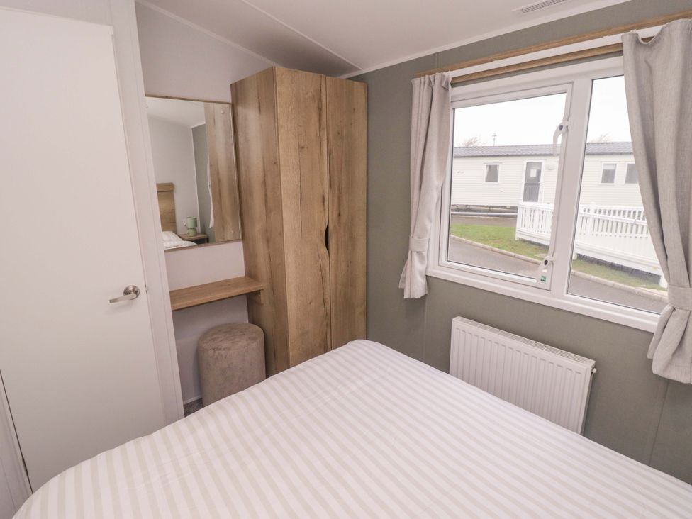 A bedroom with a bed and wardrobe at 47 Chestnut Road in Porthcawl
