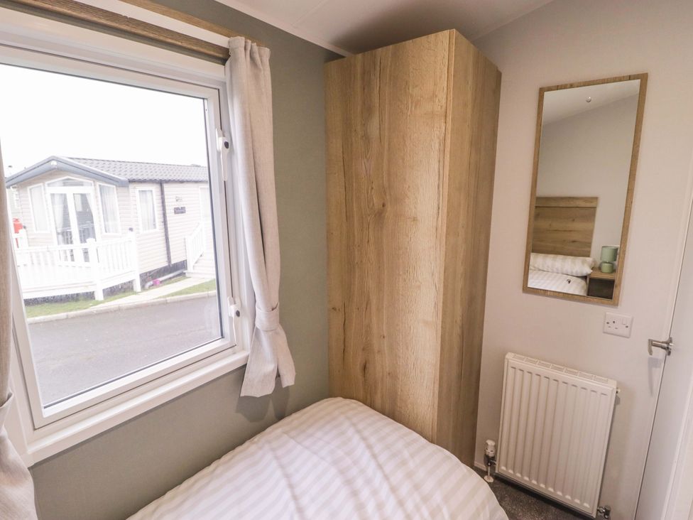 A bedroom with a window and wardrobe at 47 Chestnut Road Porthcawl