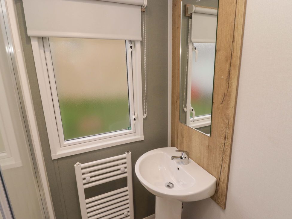 A bathroom with a sink and mirror at 47 Chestnut Road Porthcawl