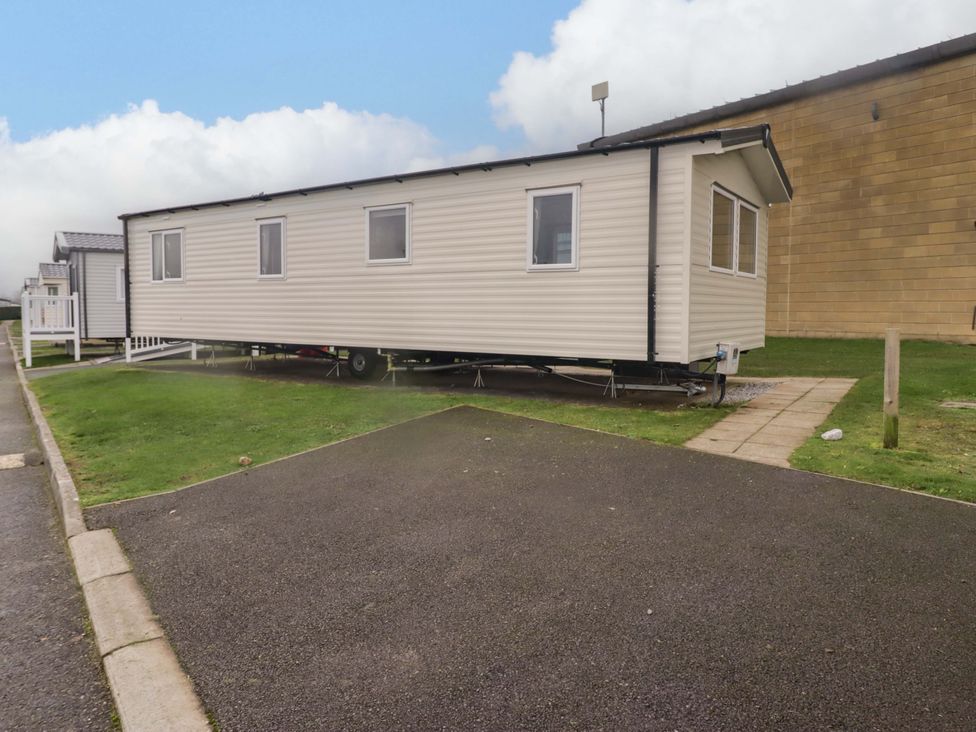 A mobile home parked on a grassy area at 47 Chestnut Road in Porthcawl