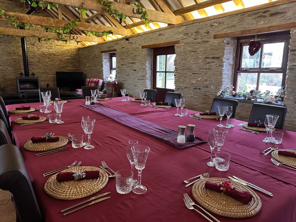 A dining room with a large table set for a meal at Jabajak in Whitland
