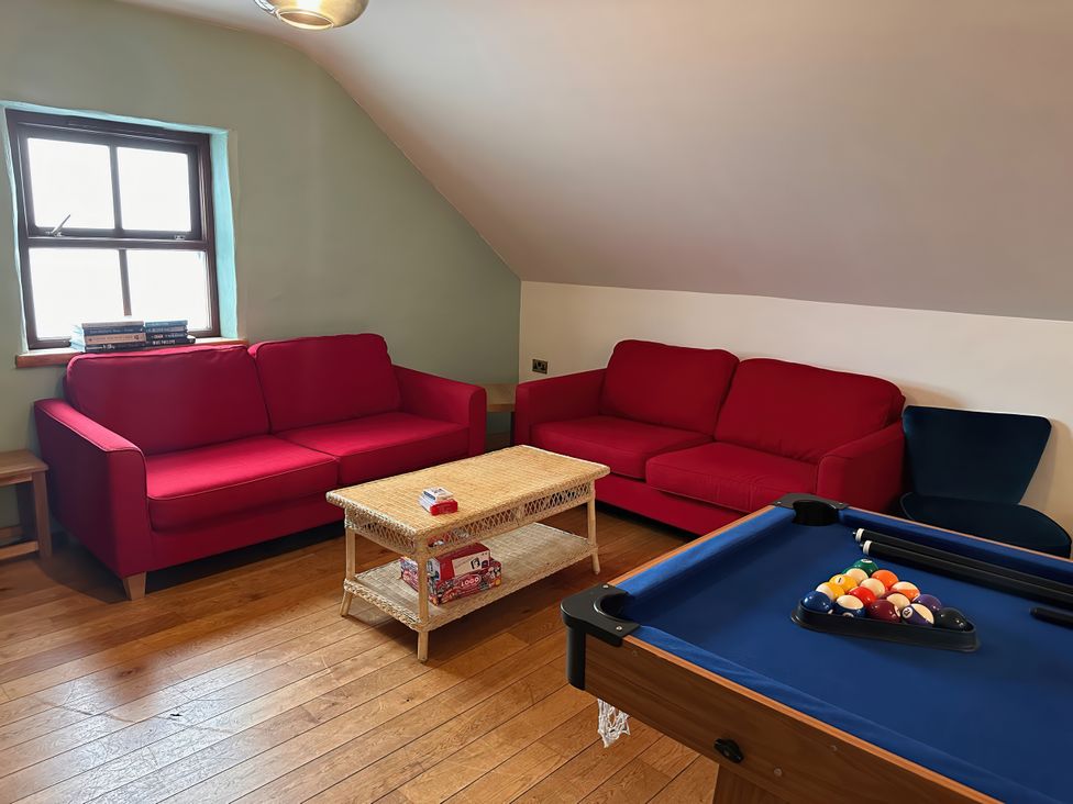 A game room with sofas and a pool table at Jabajak in Whitland