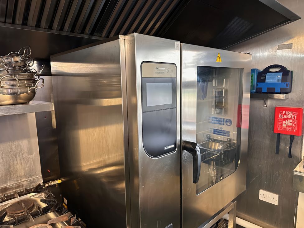A kitchen with a refrigerator and cooking range at Jabajak in Whitland