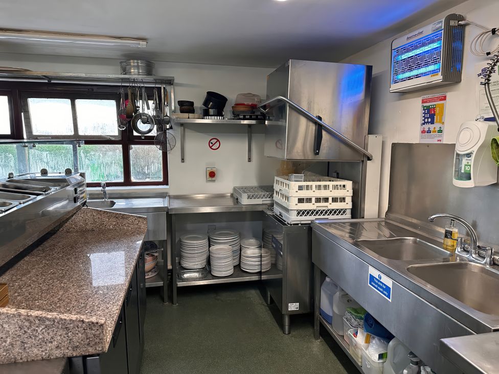 A kitchen with stainless steel sink and workspace at Jabajak in Whitland