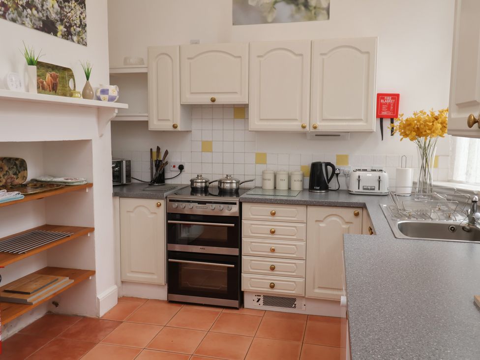 A kitchen with cabinets and appliances at Duke Cottage in Woodbridge