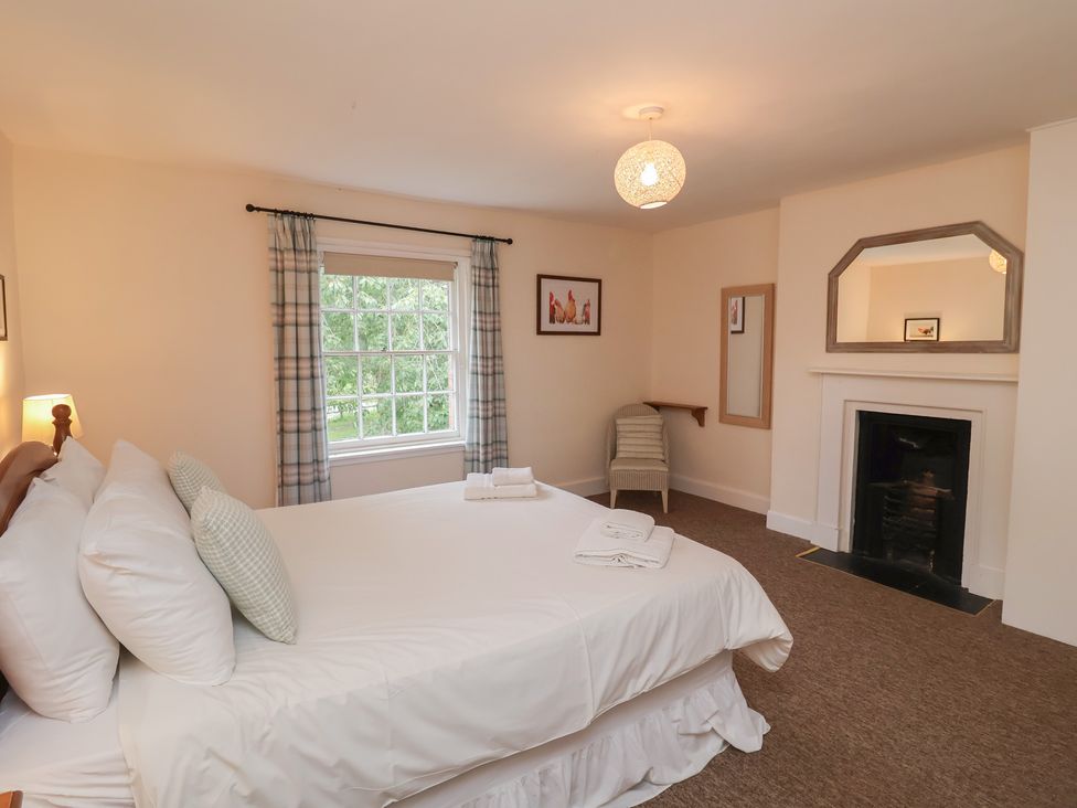 A bedroom with a bed and a window at Duke Cottage in Woodbridge