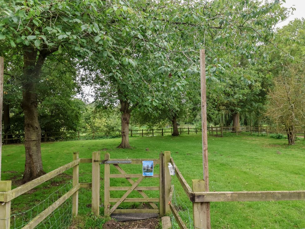 An outdoor area with a gate and trees at Duke Cottage in Woodbridge