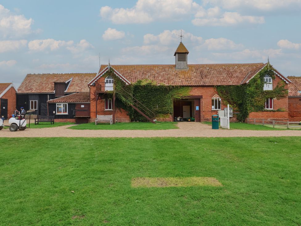 A building surrounded by grass and a pathway at Duke Cottage in Woodbridge