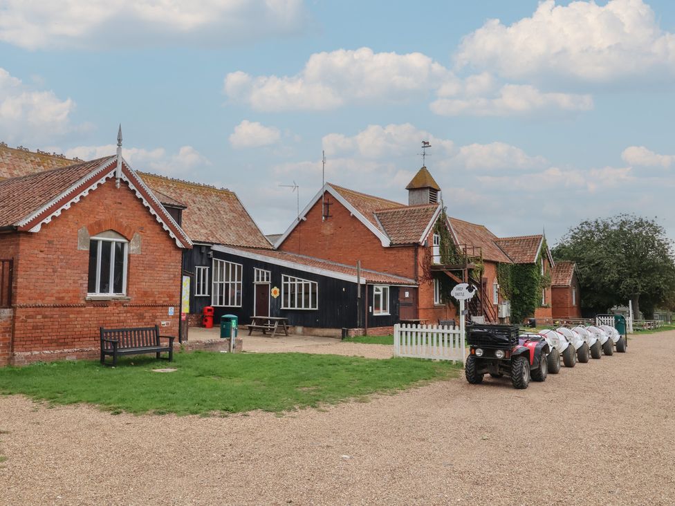 A view of buildings with a bench and ATV at Duke Cottage in Woodbridge