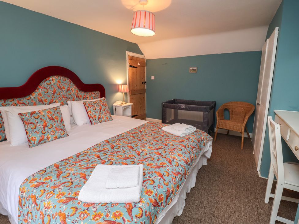 A bedroom with a bed and a crib at Duchess Cottage in Woodbridge