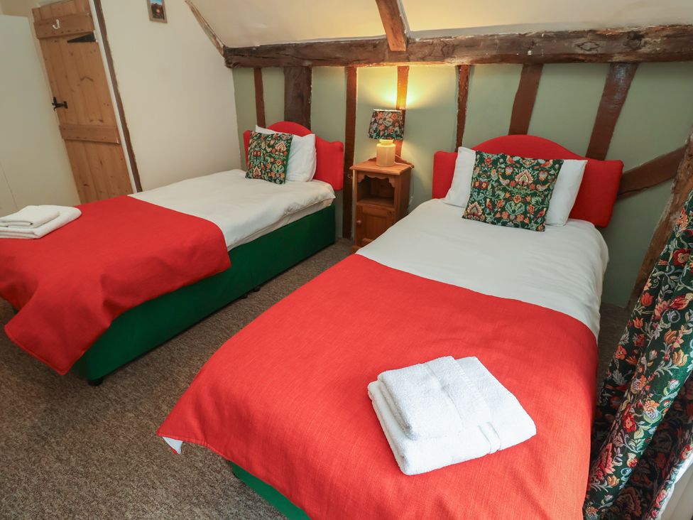 A bedroom with two beds and a nightstand at Duchess Cottage Woodbridge
