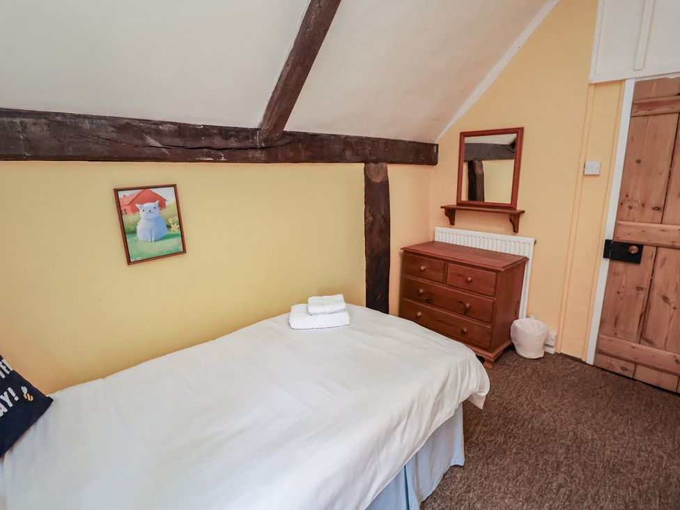 A bedroom with a bed and dresser at Duchess Cottage in Woodbridge
