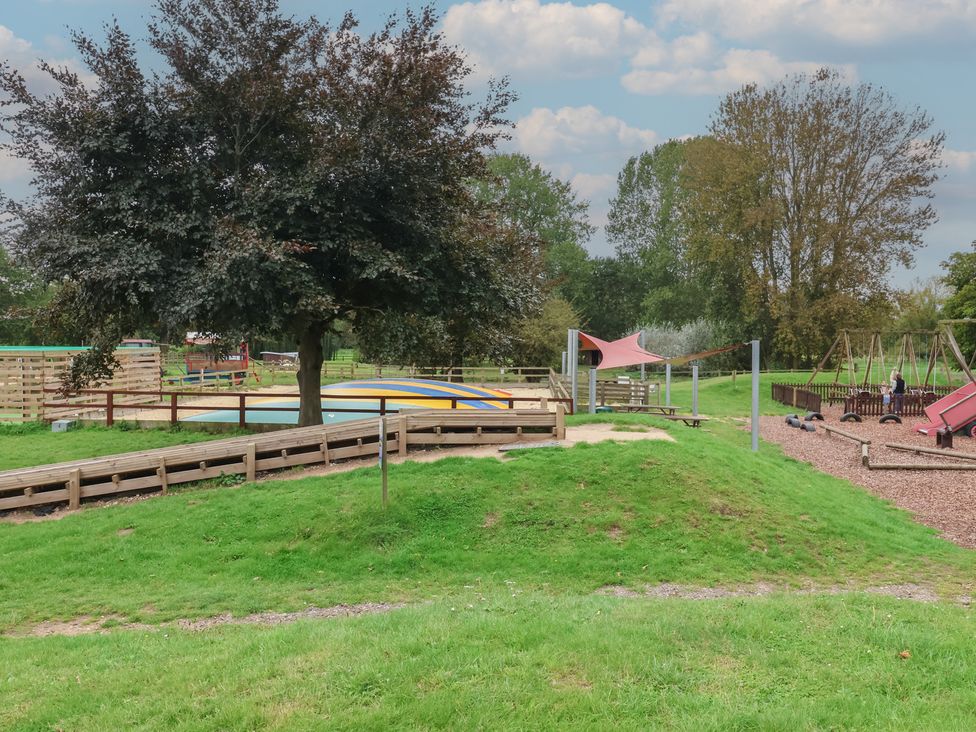 A playground with swings and a slide at Duchess Cottage in Woodbridge