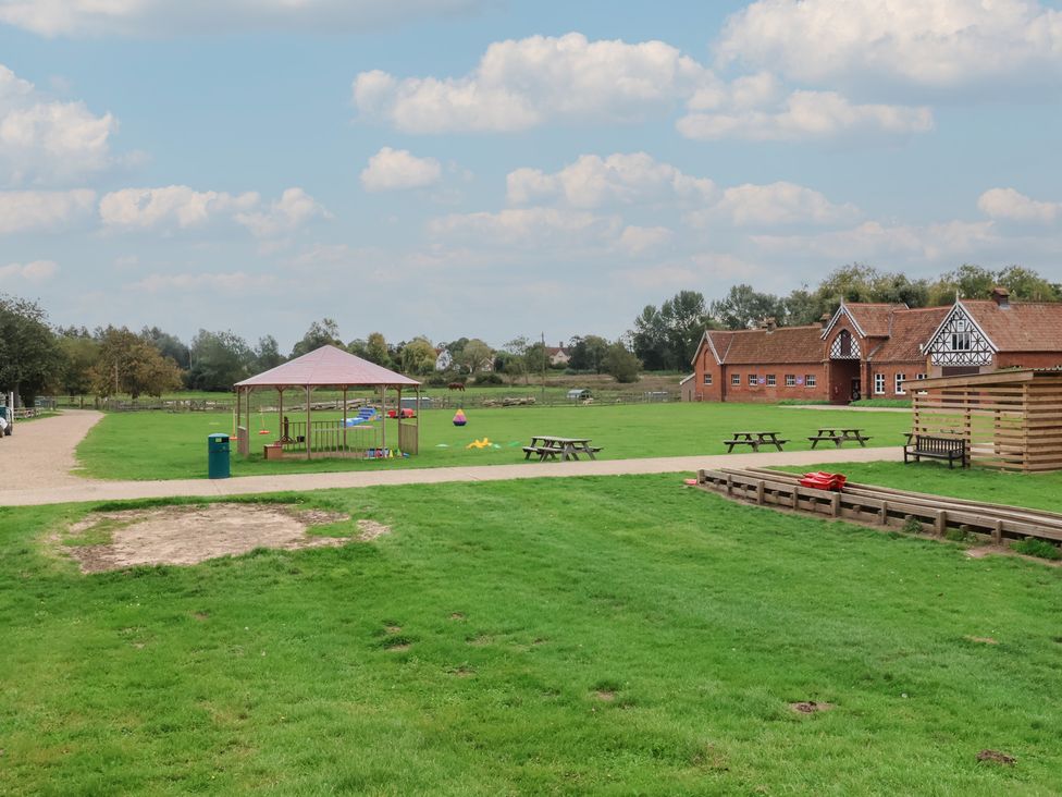 An outdoor area with a gazebo, picnic tables, and a building at Duchess Cottage in Woodbridge