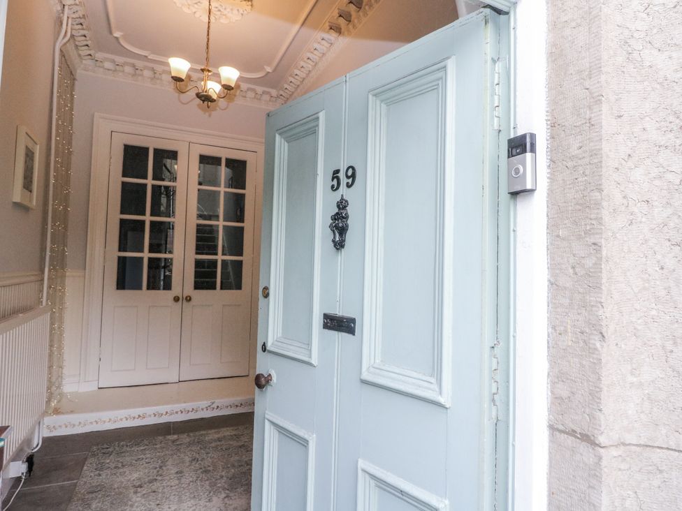 A hallway with a front door and closet at Rowan Tree House Brechin