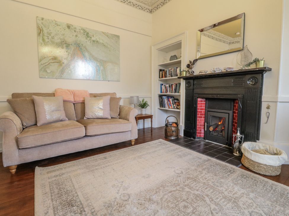 A living room with a sofa and fireplace at Rowan Tree House Brechin