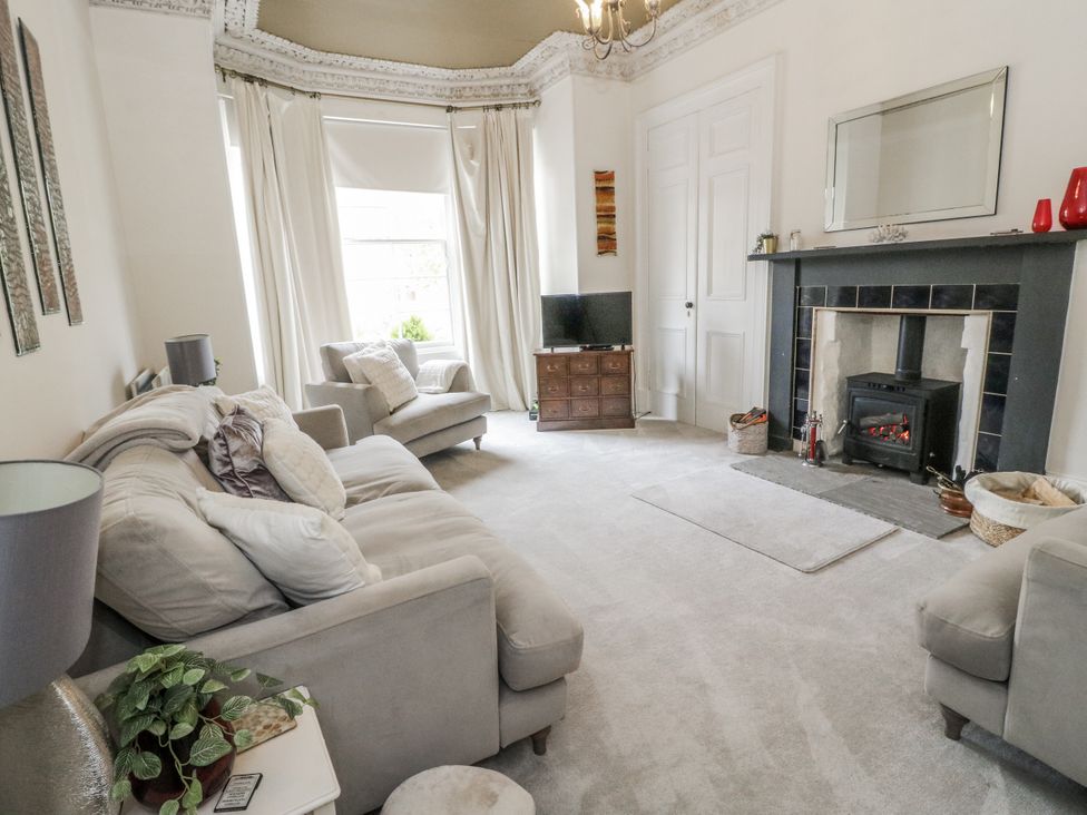 A living room with a fireplace and television at Rowan Tree House Brechin