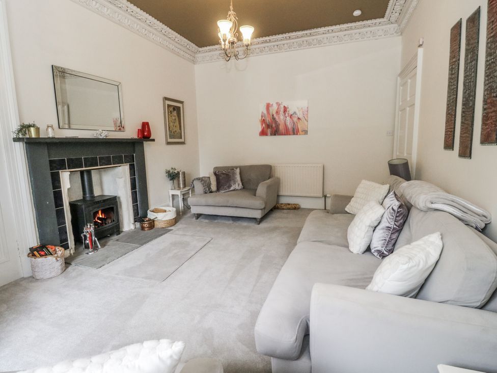 A living room with a fireplace and sofa at Rowan Tree House Brechin