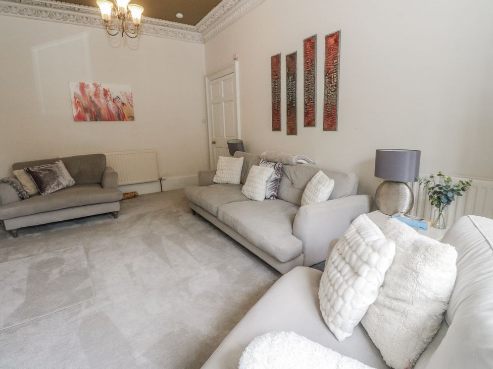 A living room with sofas and wall art at Rowan Tree House Brechin
