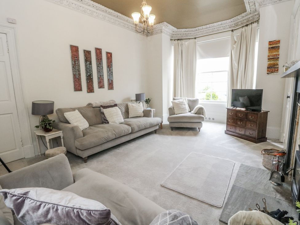 A living room with a sofa and television at Rowan Tree House Brechin