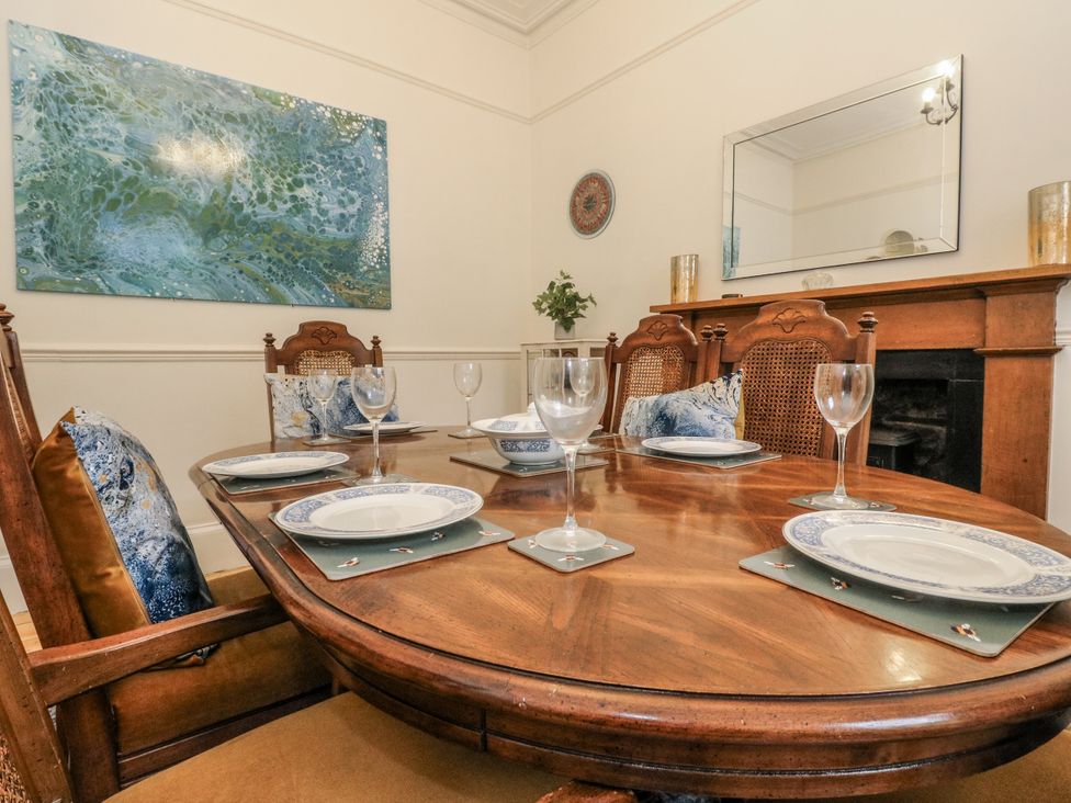 A dining room with a table set for meals at Rowan Tree House in Brechin